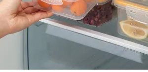 Detailed view of clear plastic food storage container in fridge, practical fruit organizer box.