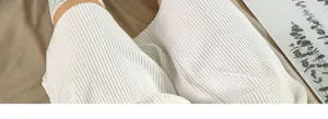 Close-up detail of white ribbed knit loungewear pants featuring soft textured fabric.