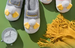 Plush cotton slippers detail showcasing soft grey white fleece and cute chick pom-pom decoration.