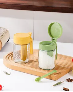 Gedetailleerd overzicht van glazen kruidenpot met lepel en deksel voor in de keuken.