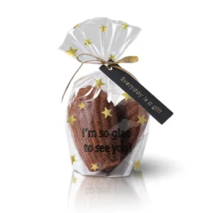 Transparent stand up packaging bag with gold stars ribbon for homemade cookies pastry bakery detail