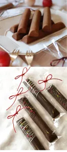 Detailed view of long rectangular artisanal baked financiers packaged in clear bags with red bows.