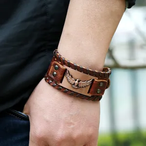 Plano de detalle de pulsera de cuero punk vintage con tótem de águila de metal y diseño trenzado.