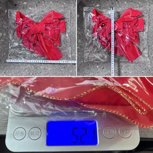 Detailed view showing the size and weight measurement of the red Christmas bow decoration.