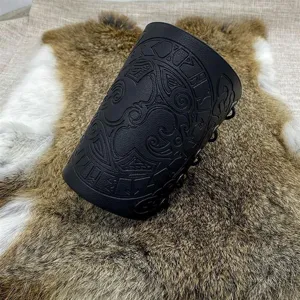 Close-up detail of black leather Viking bracer featuring embossed Norse runes and raven patterns.