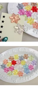 Primer plano cuentas copos de nieve de acrilico de colores, ideal manualidades de joyeria DIY.