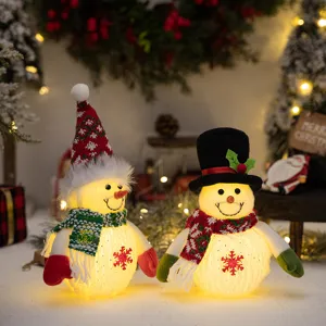 Gedetailleerd overzicht van knuffels van een kerstsneeuwpop met lichten en feestelijke mutsen.