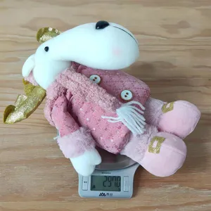 Detailed shot of the pink plush elk doll showing weight on scale, cute Christmas decor.