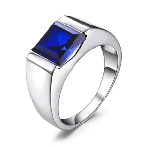 Close up detail of men square blue gemstone ring with polished silver band and vibrant stone.