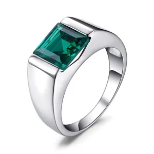 Detailed view of men fashion silver ring with emerald cut green stone modern sleek design jewelry