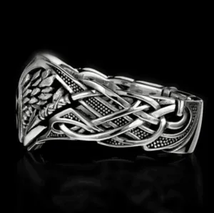 Anillo vintage estilo punk de plata con patrón tejido intrincado y detalle de pluma hombre.
