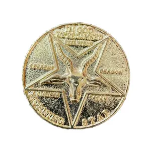 Dettaglio della moneta in metallo occulto con pentagramma inciso e scritte simboliche.