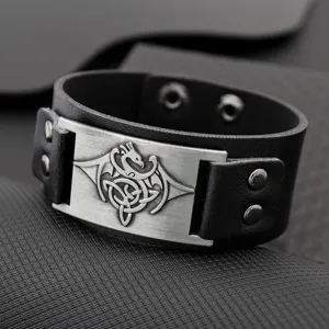 Primo piano del bracciale da uomo in pelle nera gotica con targa in metallo drago.
