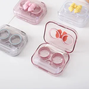Detailopname van snoepkleurige contactlenzendoosjes met strikjes en transparant draagbaar ontwerp.