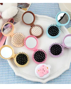 Brosse à cheveux coussin d'air pliante portable avec miroir, détail de mini peigne de massage.