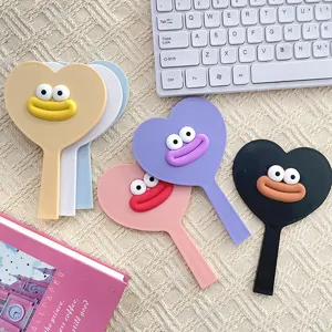 Close-up detail shot of cute heart-shaped hand mirrors with funny 3D lips and eyes.