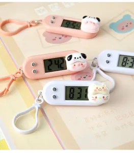 Close-up detail of cute cartoon digital clock keychain with cute animal designs for students.