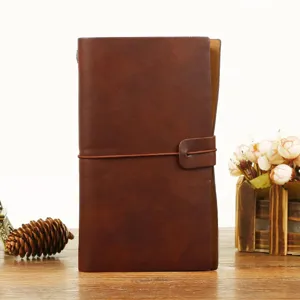 Vue détaillée du carnet en cuir marron vintage avec fermeture à lanière et design pratique.