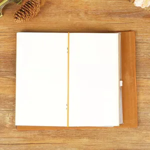 Carnet de notes A6 en cuir vintage avec bande élastique et pages intérieures vierges écriture.