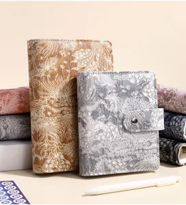 Vista dettagliata di quaderni ad anelli in jacquard cinese con eleganti copertine in tessuto.