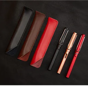 Detail view of handmade leather pen sleeves and matching metal fountain pens neatly arranged.