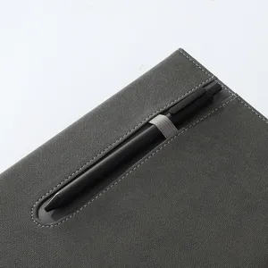 Grey business minimalist notebook with pen holder elastic band and black gel pen for office work.