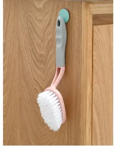 Detalle del cepillo de limpieza con cerdas blancas densas y un mango ergonómico cómodo.