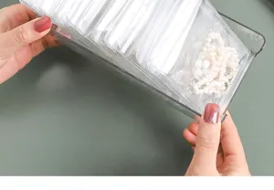 Clear jewelry storage box detail showing transparent organizer holding small anti-oxidation bags.