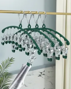 Multi-clip clothes hanger detail showing stainless steel clips and green arch frame for socks.