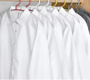 Wit shirt met lange mouwen en knopen hangt aan gekleurde kledinghangers in kast