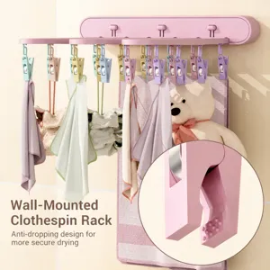 Wall-mounted folding clothes drying rack with clips, space-saving pink laundry organizer.