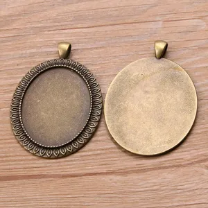 Primo piano di vassoi pendenti in lega di bronzo vintage per artigianato di bigiotteria.