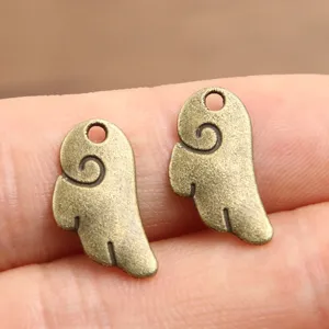 Close-up detail of vintage bronze alloy wing charms, showing fine engraved texture for DIY.
