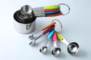 Dettaglio del set di misurini e cucchiai in acciaio inossidabile con chiare marcature di contenuto.