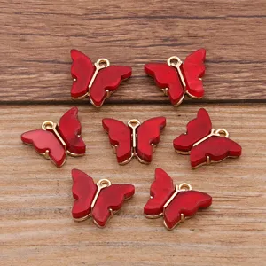 Detail shot of red acrylic butterfly charms with gold loops for DIY jewelry making crafts.