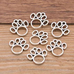 Nahaufnahme Detail von silberfarbenen hohlen Pfotenabdruck Metall Anhängern für DIY Schmuck Zubehör.
