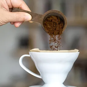 Dettaglio cucchiaio da caffè in legno, misurino per polvere di caffè, tè e latte in polvere.