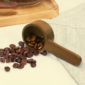 Vista dettagliata di cucchiaio da caffè in legno e misurino, ideale per chicchi di caffè e tè.