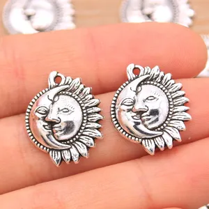 Gros plan sur les détails et la texture du pendentif charm DIY en métal visage soleil et lune.