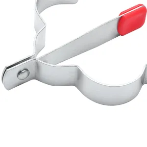 Close-up detail of stainless steel heart egg mold with red silicone handle for cooking.