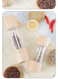 Detail view of wooden pepper grinder, manual spice mill and seasoning bottle for kitchen use.