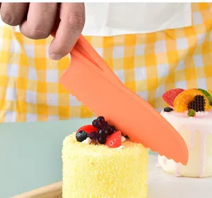 Dettaglio del coltello dentato da forno in silicone arancione che mostra uso su torta