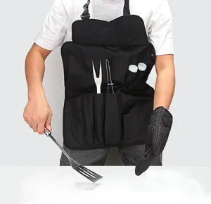 Detail shot of black BBQ apron with tool pockets, holding stainless steel spatula and tools.