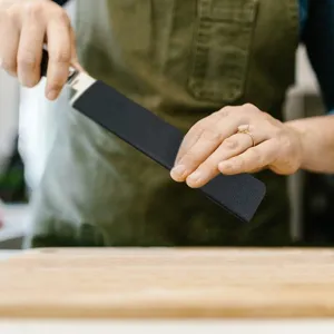 Close-up view of black flocked knife sheath protecting kitchen cutlery safely in use.