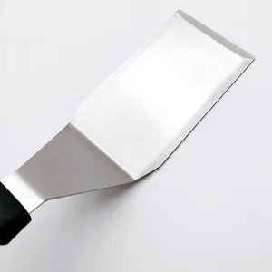 Detail shot of stainless steel barbecue spatula with ergonomic black handle for outdoor grill.