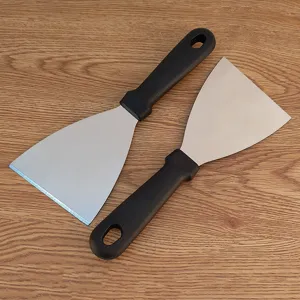 Stainless steel grill scraper with black plastic handle, durable metal spatula for outdoor BBQ.