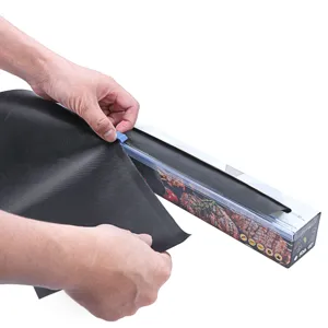 Non-stick BBQ grill mat detail showing the black Teflon sheet being pulled from cutter box.