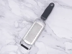 Stainless steel lemon zester and cheese grater with comfortable handle for kitchen use.
