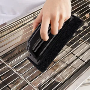 BBQ grill cleaning brush detail view showing durable black scrubbing pad and ergonomic handle.