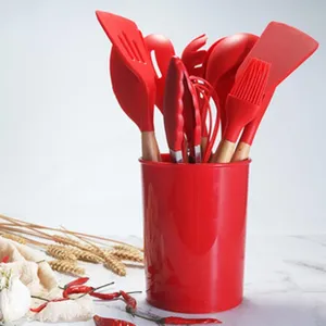 Red silicone kitchen utensil set detail, non-stick spatula and spoon in storage holder.